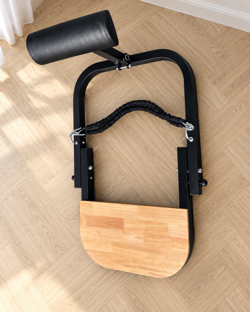 Station Hip Thrust vue de dessus sur un parquet clair, avec ses élastiques et sa plateforme en bois