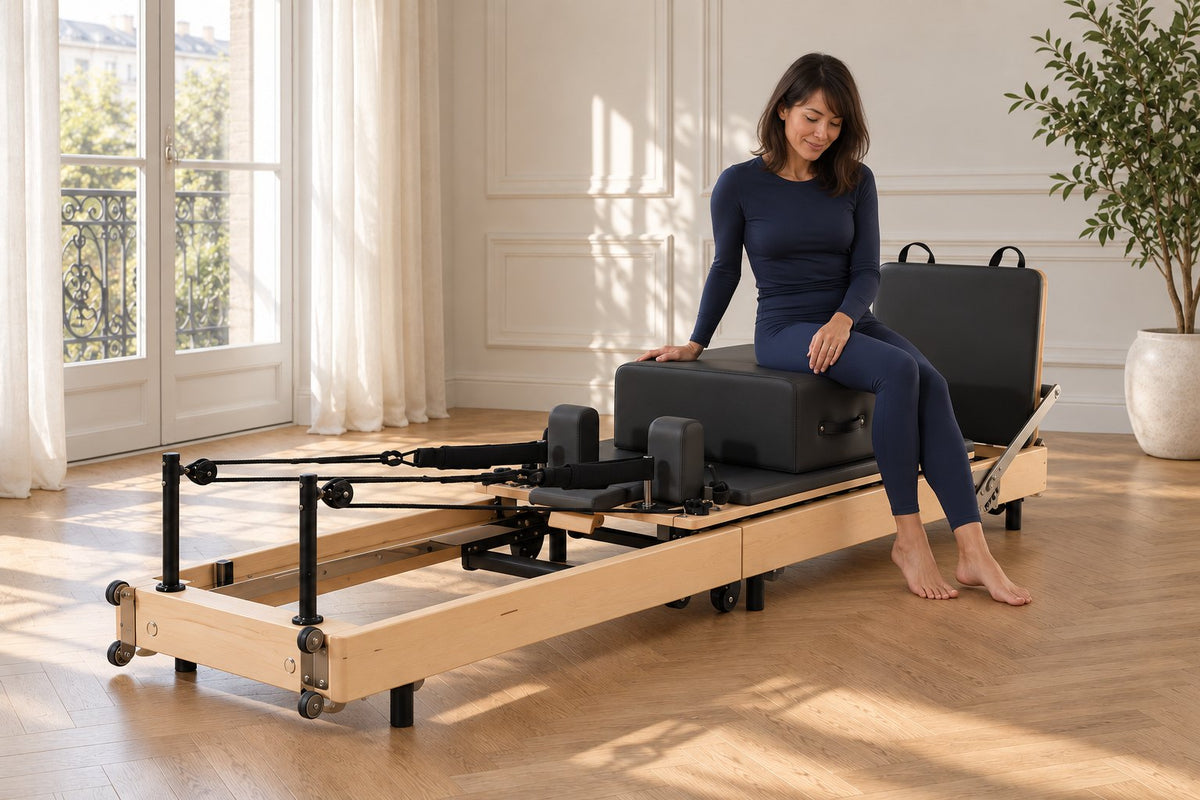 Une femme assise sur la box du Plissé, près d'une porte-fenêtre